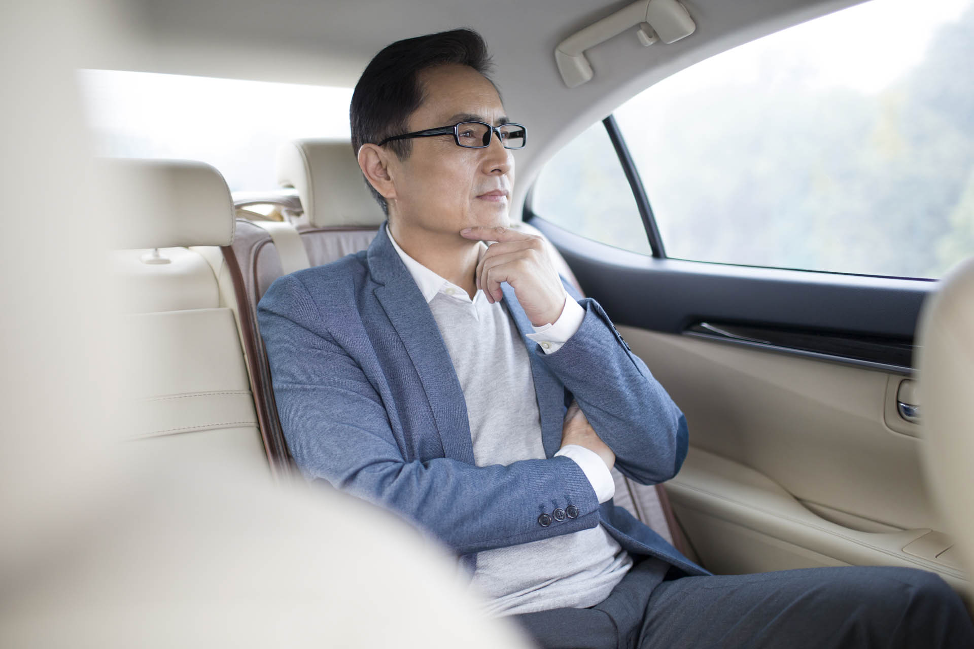 A business traveler in the back of a luxury car